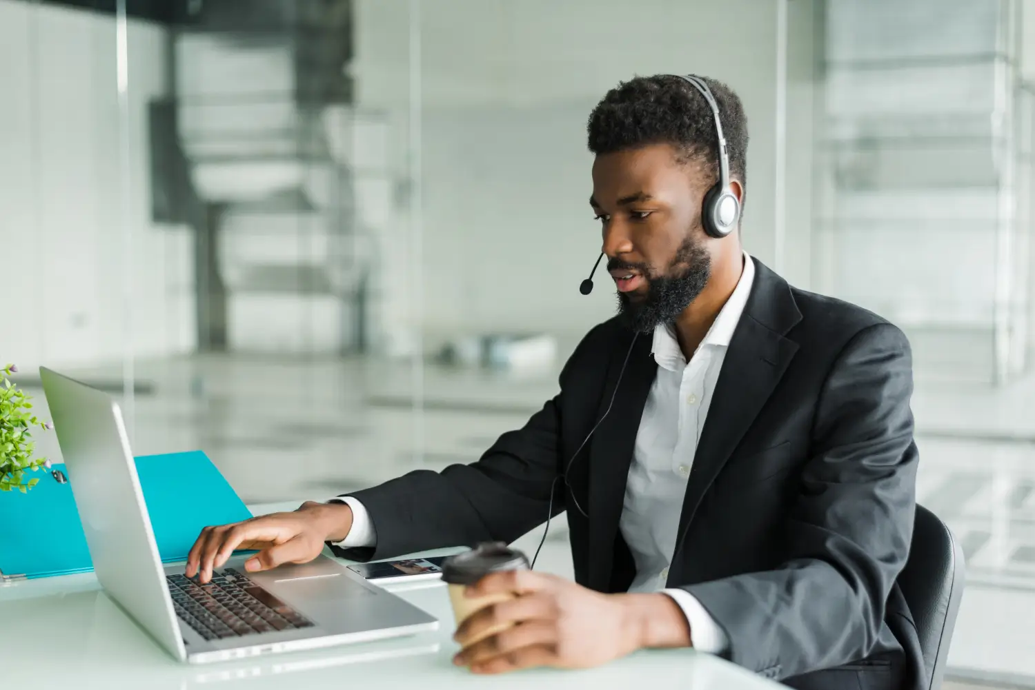 63871e08eb97d4f806d61fbb_african-american-man-customer-support-operator-with-hands-free-headset-working-office (1)